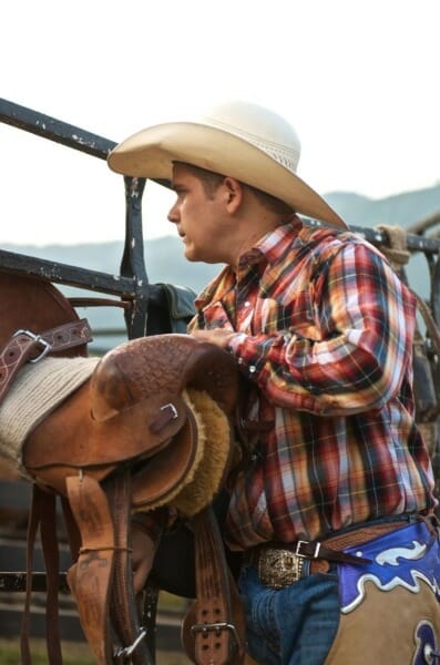 Cowboy preparing saddle